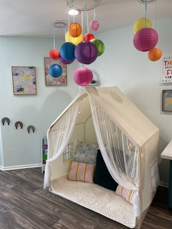 Childrens playroom with colorful paper lanterns and house tent